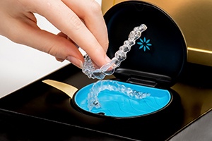 a person putting Invisalign trays into their protective case