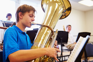 a teen playing a tuba in their school band