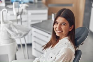 a patient smiling and sitting in a dental chair