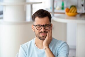 a man holding his mouth because he has a toothache